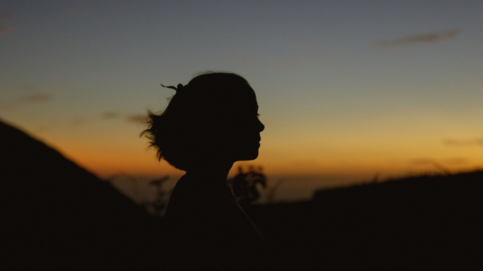 Silhouette of a woman with sunset background in Anton Valley provides a dramatic, serene ambiance.